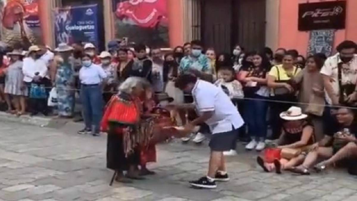 Tierno video: hombre arma colecta para dos abuelitas en pleno desfile de las delegaciones de la Guelaguetza