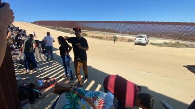 Más de 50 migrantes cruzan muro en EU; patrulla los hace esperar en el cerco