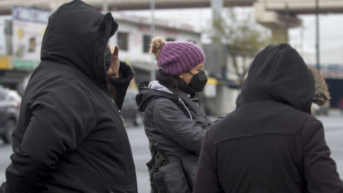 Gente usando chamarras y gorros ante el frío en la Ciudad de México