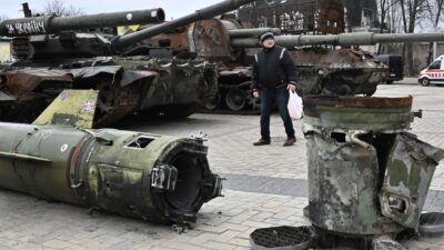 Ucrania Rusia invasión, hombre camina entre tanques rusos destruidos