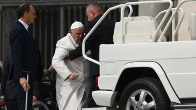 Papa Francisco, hombre cargando al Papa hacia el papamóvil