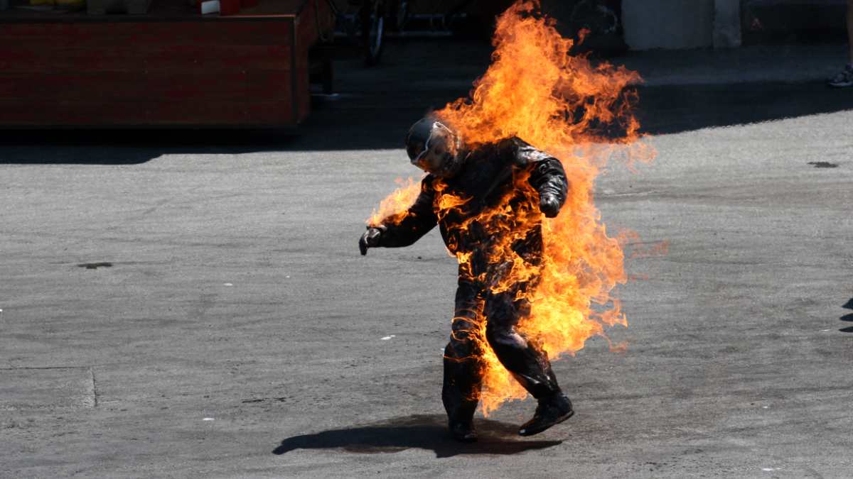 hombre lanza bicicleta a sujeto en llamas