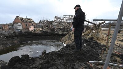 Ucrania hombre mira el cráter que dejaron los bombardeos de Rusia