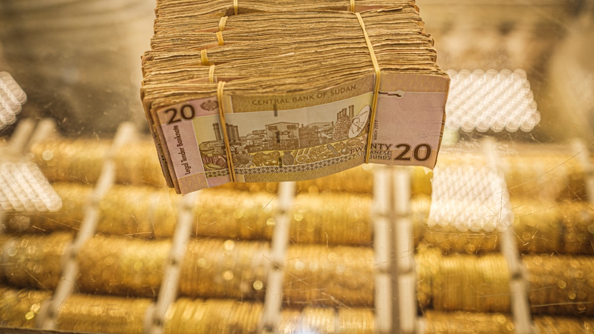 Guerra Sudán, fajo de billetes sobre modenas de oro en un mostrador de Jartum