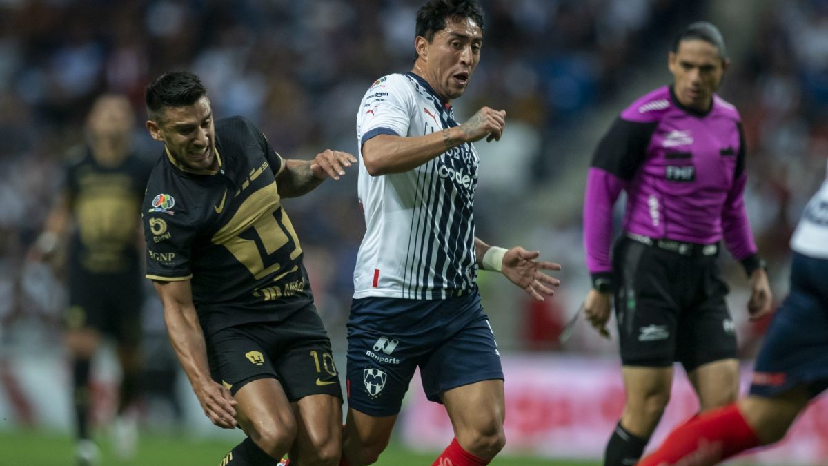 Jugadores de Pumas y Monterrey disputan el balón en partido de la Liga MX