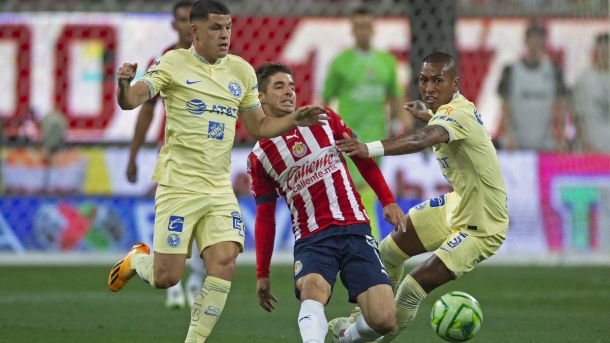 Jugadores del América disputan el balón ante Chivas