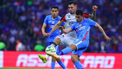 Jugadores de Cruz Azul y Atlas disputan el balón en partido de la Liga MX