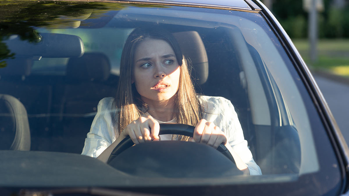 Movilidad concentración: Mujer asustada conduciendo un automóvil