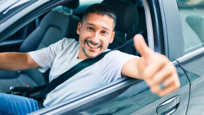 Consejos buen conductor: Automovilista saludando por la venanilla del coche